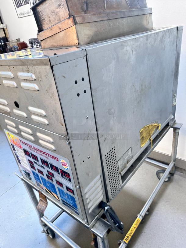 Commercial stainless steel food warmer on wheels, visible troubleshooting guide and control labels. Used condition.