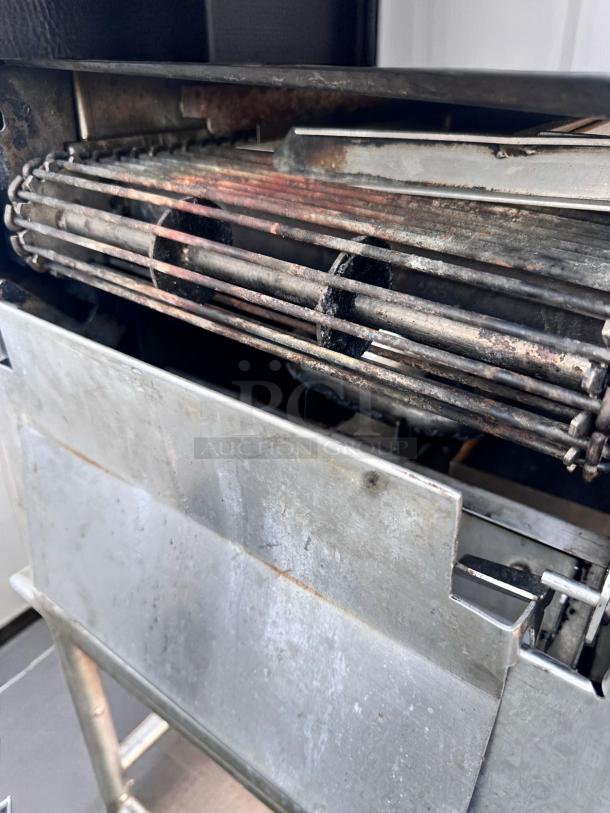 Metal industrial heater with visible heating elements, showing signs of rust and wear. Metal casing intact, functional condition.
