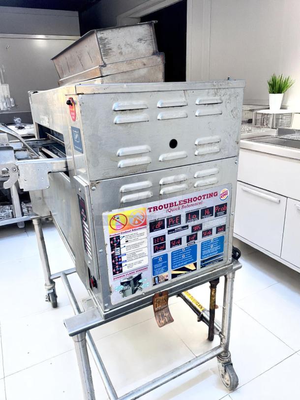 Commercial conveyor toaster in stainless steel, used condition. Features troubleshooting guide with diagrams on the side.