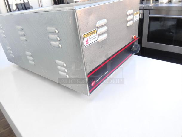 Stainless steel commercial oven by Edward Don & Company with ventilation slots, warning labels, and visible control knob.