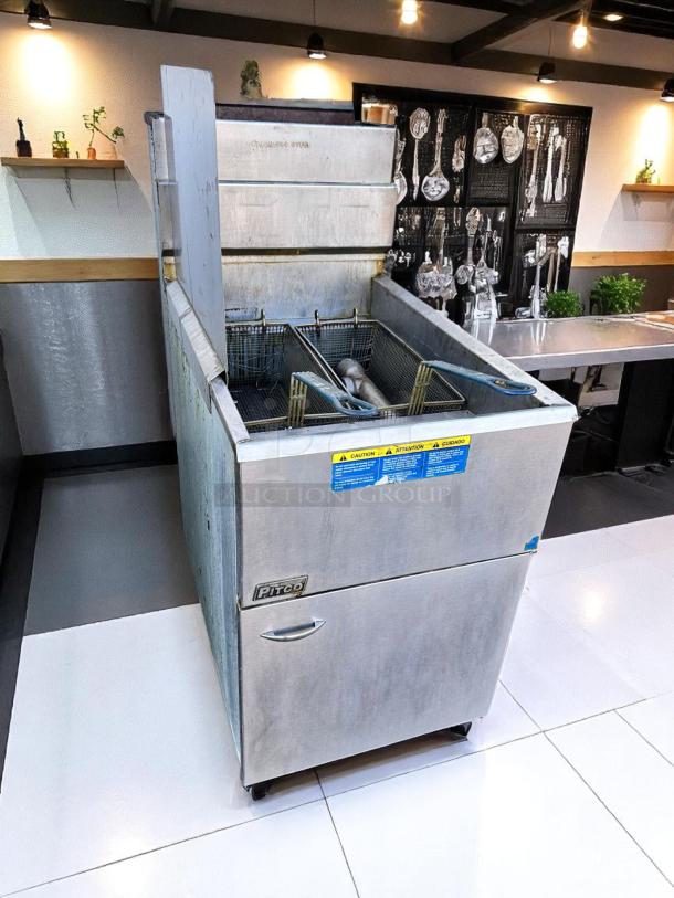 Commercial Pitco deep fryer with dual baskets, stainless steel, visible caution labels, good condition.