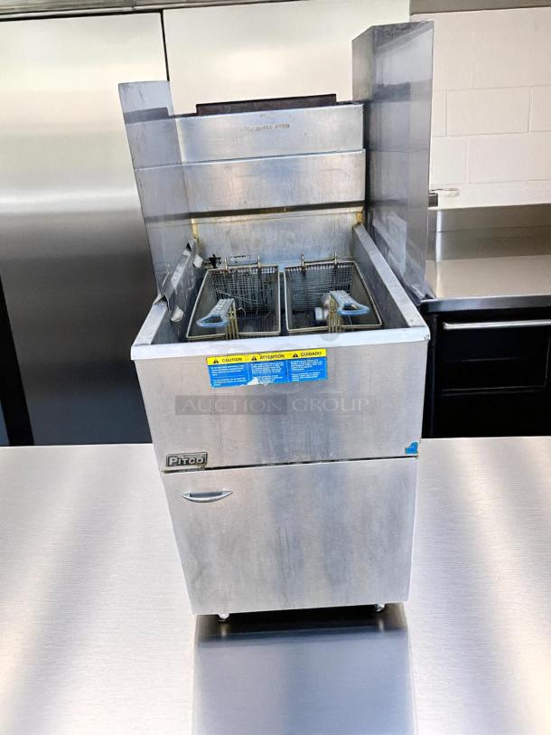 Pitco commercial deep fryer, dual-basket, stainless steel, used condition, warning labels visible, open fry area.
