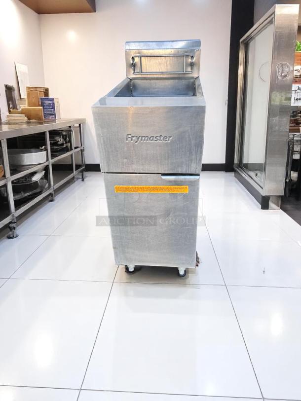 Commercial Frymaster deep fryer with stainless steel finish, in good condition, featuring a hopper and wheels for mobility.