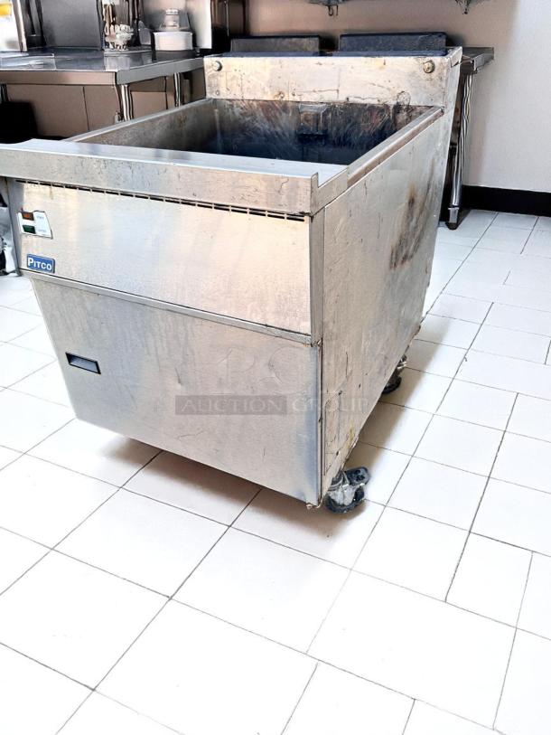 Commercial fryer by Pitco, stainless steel, on wheels, visible wear and tear, suitable for industrial kitchen use.