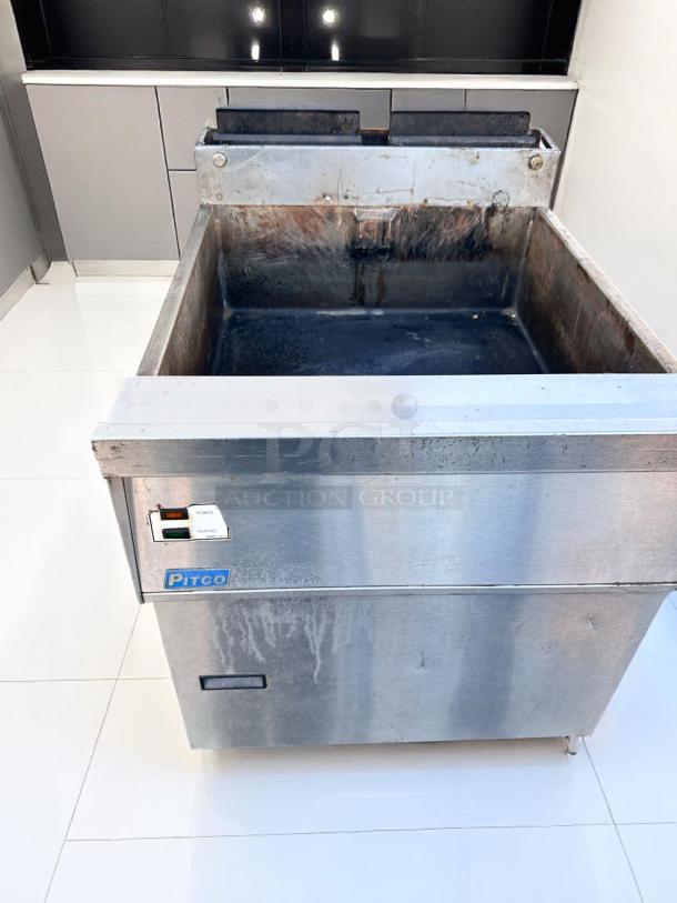 Pitco commercial deep fryer in stainless steel, well-worn condition, visible power and heating switches, suitable for high-volume cooking.