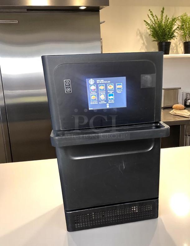 Commercial beverage dispenser with touchscreen, black, lightly used. Display shows product options. Ideal for cafes or offices.