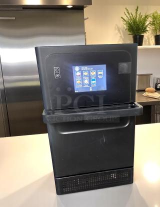 Commercial beverage dispenser with touchscreen, black, lightly used. Display shows product options. Ideal for cafes or offices.