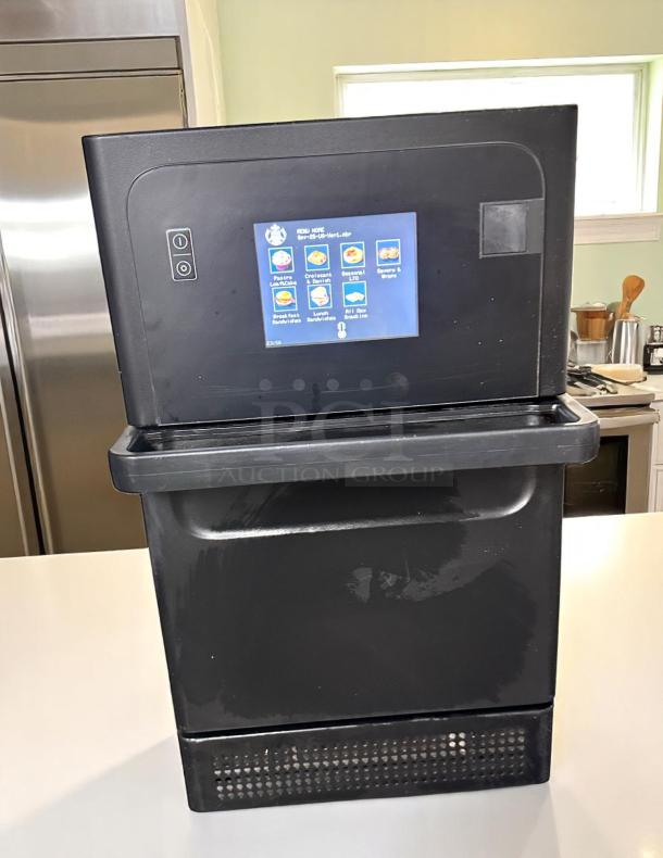 Commercial food vending machine with touchscreen interface displaying menu items. Black finish, fair condition.