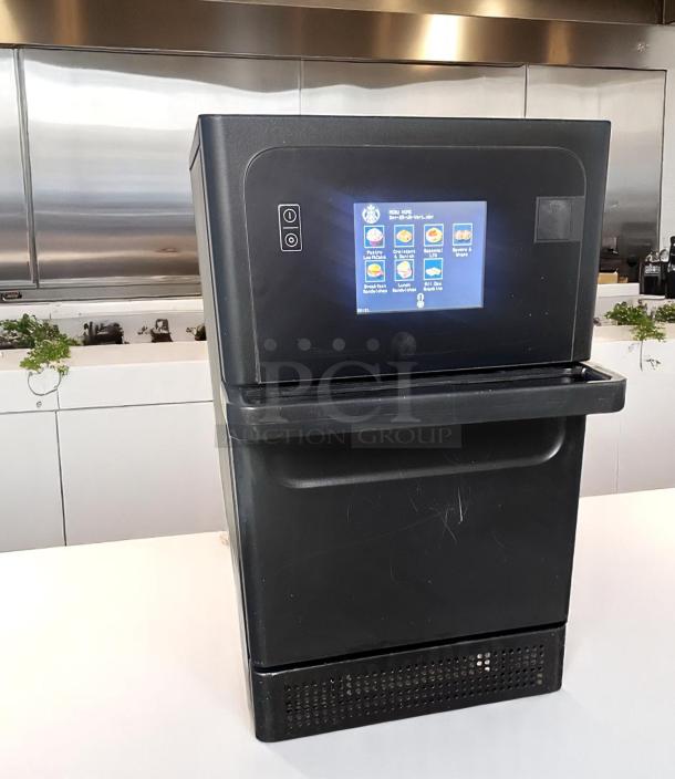 Commercial-grade black coffee machine with touchscreen interface displaying menu options. Used condition with slight surface wear.