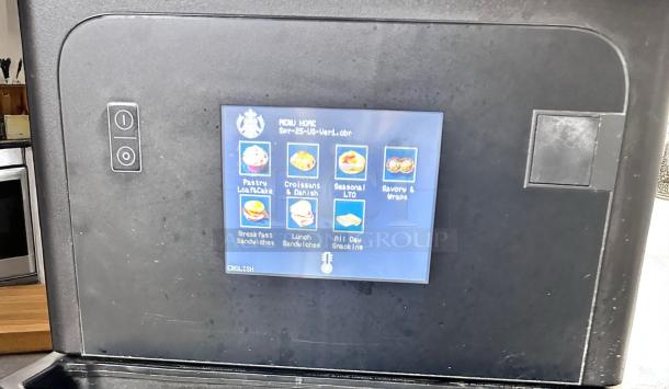 Commercial touchscreen vending machine menu panel with various food options displayed, including pastries and sandwiches.