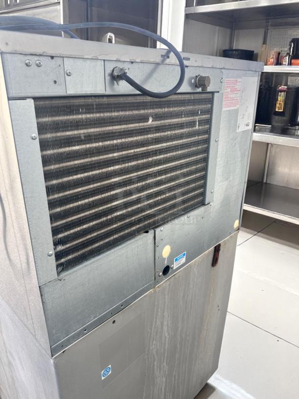 Commercial metal ice machine, industrial design, showing ventilation grill. Unit has visible watermarks, indicating prior use.