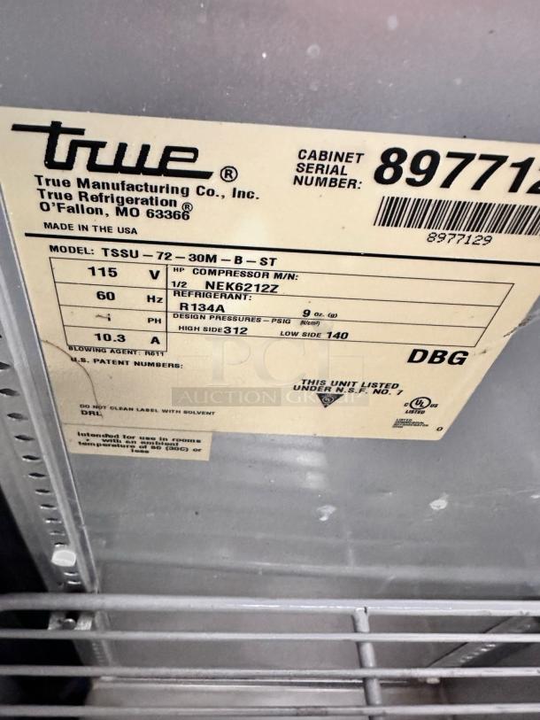 Close-up of a True Manufacturing Co. label on a refrigerator, model TSSU-72-30M-B-ST, serial number 8977129.