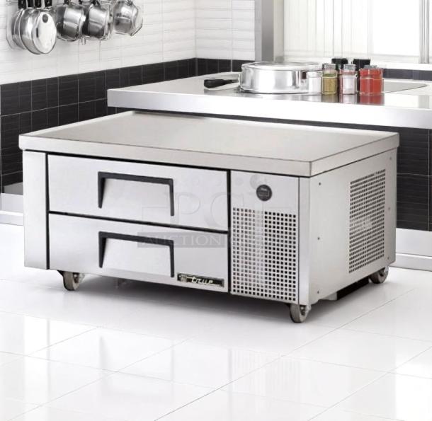 Stainless steel commercial undercounter refrigerator with two drawers and ventilation, in excellent condition, on caster wheels.
