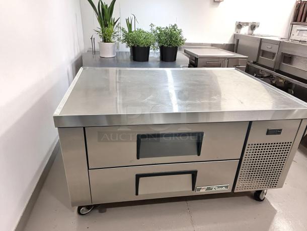 Stainless steel commercial refrigerator with two drawers, branded "True," on wheels, in excellent condition.