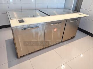Stainless steel commercial kitchen refrigerator, three doors, with a cutting board top. Excellent condition.