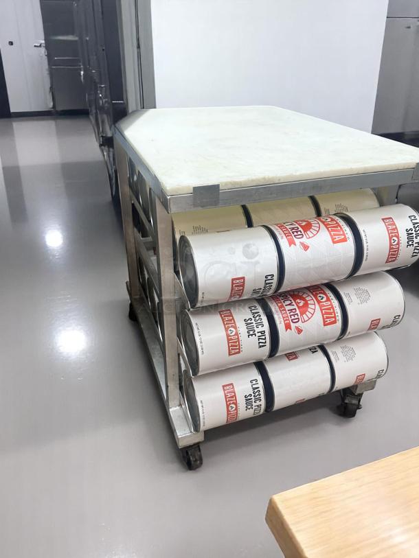 Stainless steel cart with heavy-duty wheels, holding large cans of "Classic Pizza Sauce" and "Scarlet Fire Diced Tomatoes in Juice."