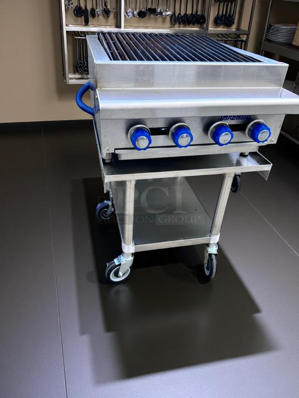 Stainless steel commercial grill with blue knobs, on wheels, Imperia branding, used condition. Ideal for restaurant kitchens.