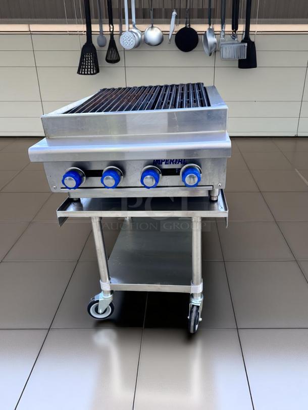 Commercial stainless steel grill on wheeled stand, blue knobs, "Imperial" branding, excellent condition.