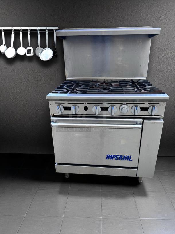 Imperial gas range with six burners, stainless steel, commercial grade, good condition, visible logo on oven door.