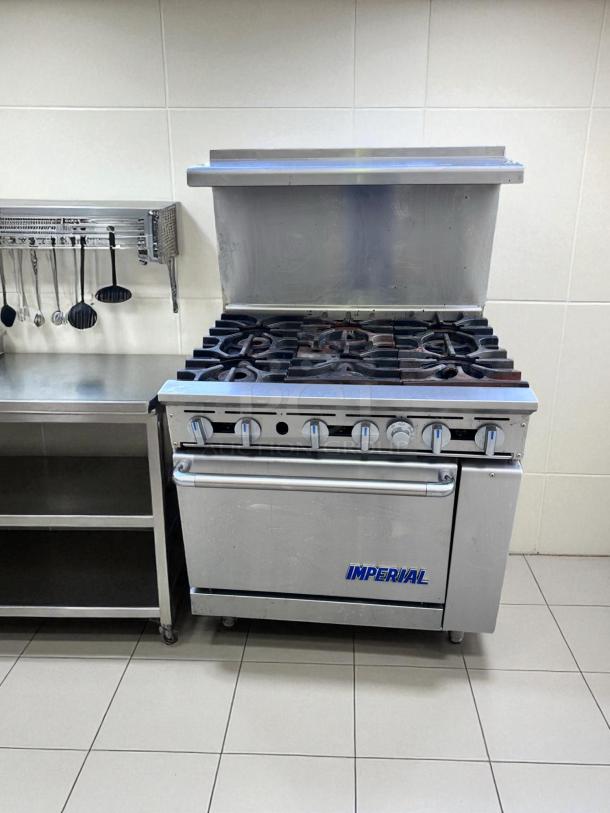 Imperial commercial stove with six burners and an oven, stainless steel, good condition. Ideal for professional kitchens.
