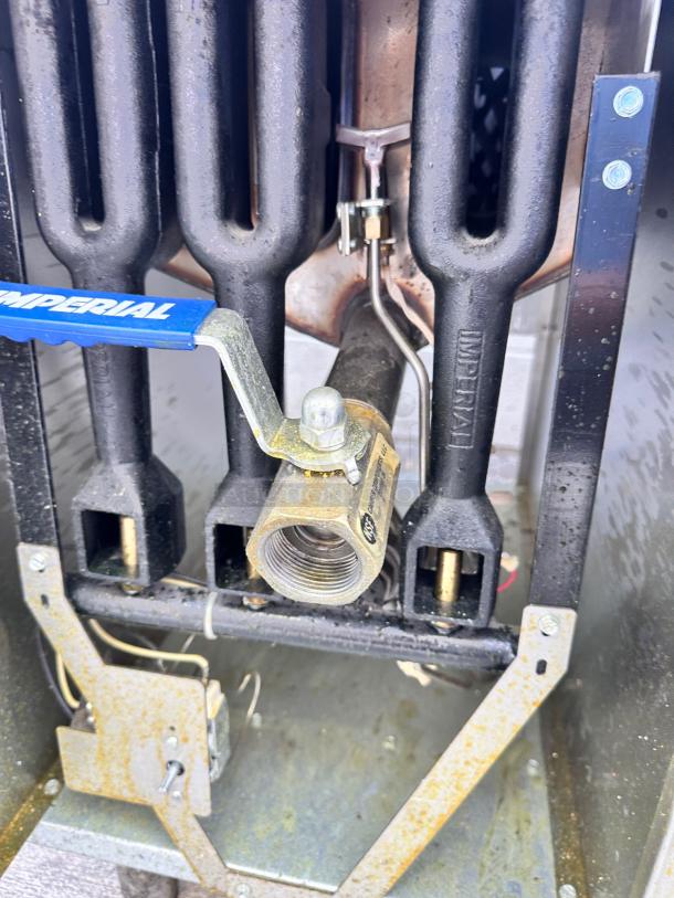 Commercial gas burner with visible Imperial brand valve, used condition, showing wear and signs of use.