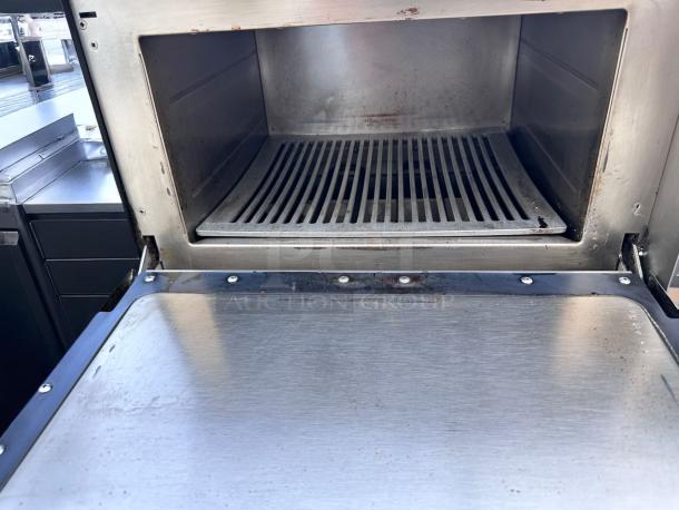 Commercial-grade stainless steel oven with grill, interior showing minor wear, ideal for professional kitchens.