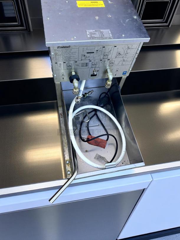Commercial coffee machine component, Frialator model. Includes hoses and wiring, visible schematic on metal surface. Used condition.