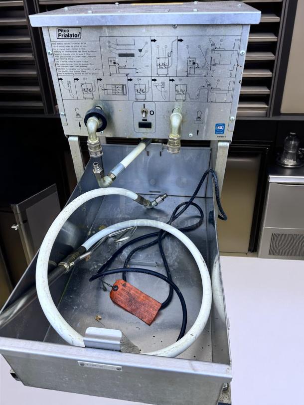 Pitco Frialator commercial fryer filter compartment with attached hoses and instructional diagram. Includes NSF certification.
