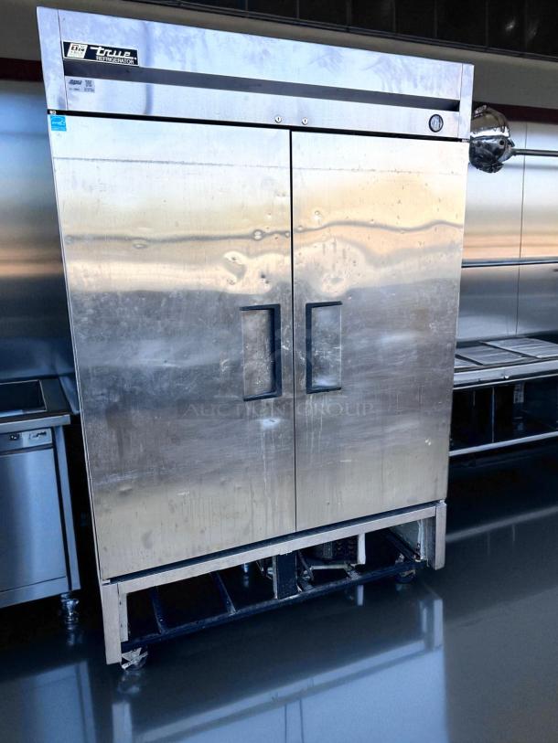 True commercial refrigerator with double doors, stainless steel, model T-49. Features include visible wear and operational temperature gauge. Ideal for restaurant use.