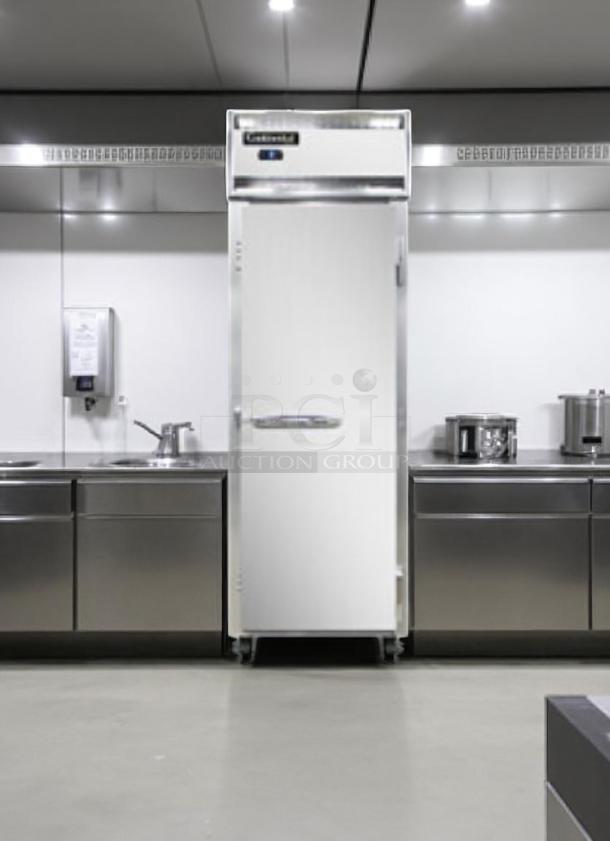 Commercial stainless steel refrigerator in a modern kitchen, featuring digital controls. Appears in excellent condition.