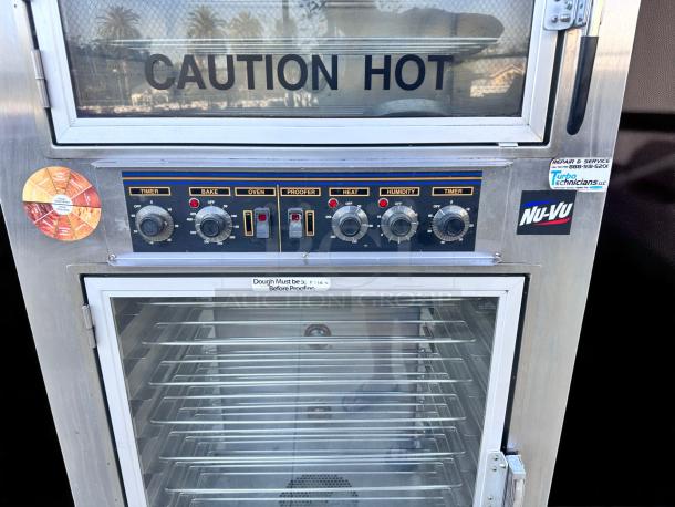 Nu-Vu commercial oven and proofer, stainless steel with control dials, labels for temperature, humidity, and timer. Caution hot sign.