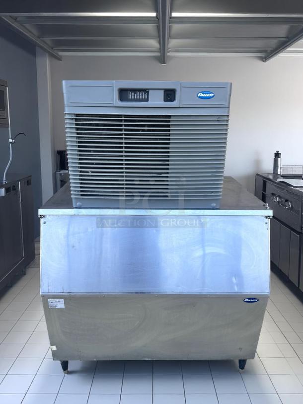 Follett commercial ice maker, stainless steel, with ventilation grille, mounted on a storage bin. Visible brand logo and labels.