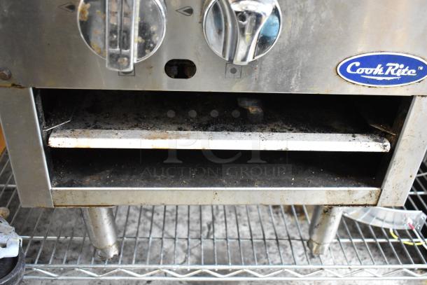 CookRite stainless steel commercial oven with control knobs, signs of wear and grime, on metal rack.