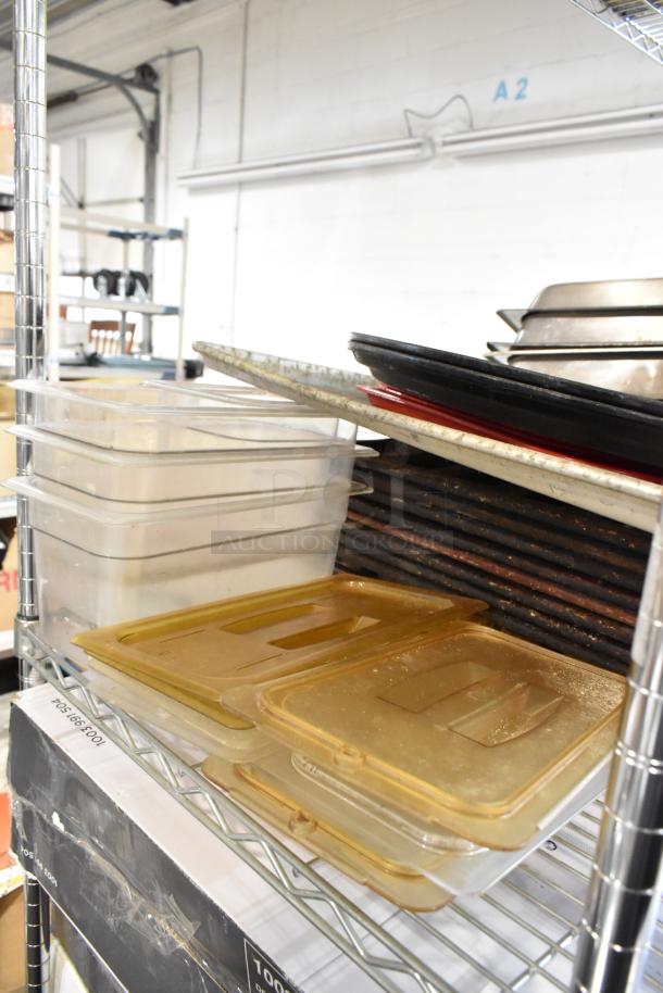 Stacked clear and black kitchen trays with lids on a storage rack, showing signs of frequent use.