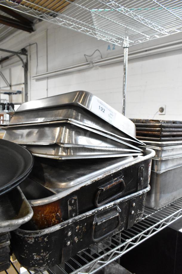 Stack of commercial-grade stainless steel baking trays on a metal shelf. Visible label: "192 QTY". Trays show moderate wear.