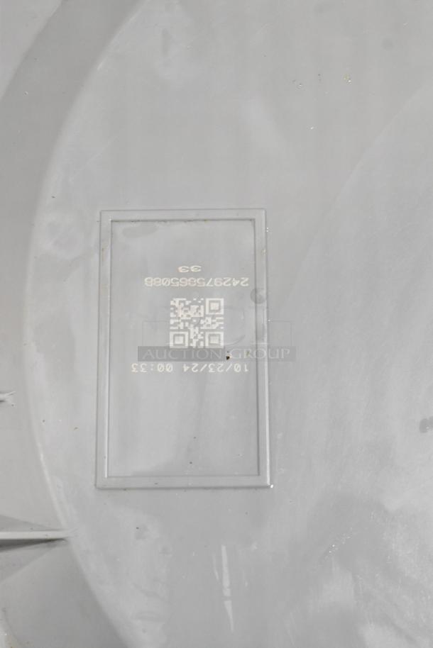 Gray surface featuring a label with QR code, numerical code 242975685088, and date 10/23/24 00:33, showing production details.