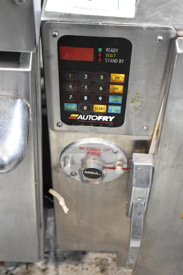 AutoFry deep fryer control panel with keypad, status lights, and fire suppression system. Stainless steel surface, moderate wear.