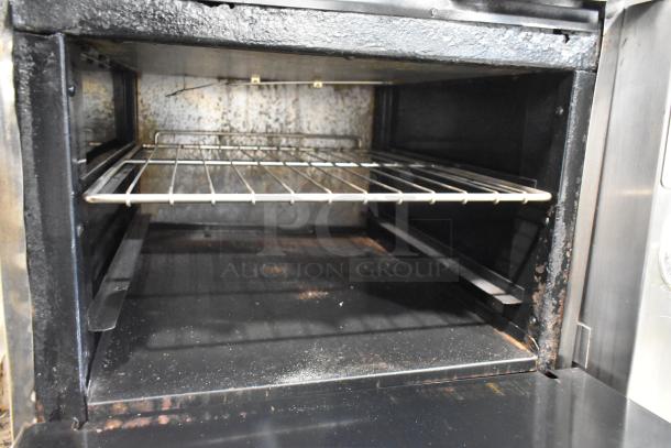 Commercial oven interior with steel rack, showing signs of wear and rust, suitable for restoration or parts.