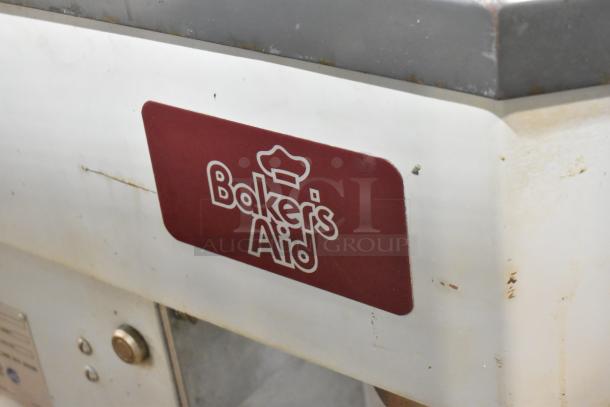 Baker's Aid industrial mixer, white body, visible wear, maroon logo label with chef hat, metal top edge.