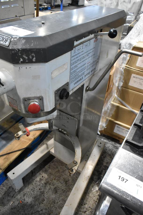 Commercial variable speed mixer, stainless steel, visible wear, emergency stop button, labeled with operating instructions.