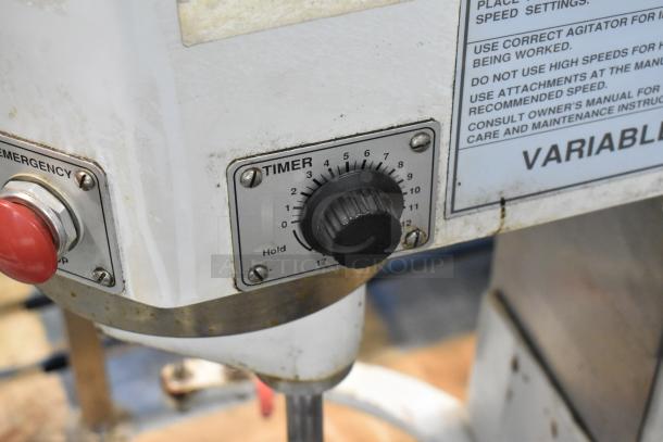 Industrial mixer timer and emergency stop button, showing signs of use. Timer dial from 0-17 minutes, label includes instructions.