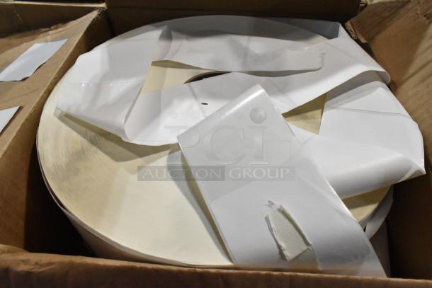 Large roll of white adhesive labels in a cardboard box, in new condition. Labels are semi-gloss with peel-off backing.