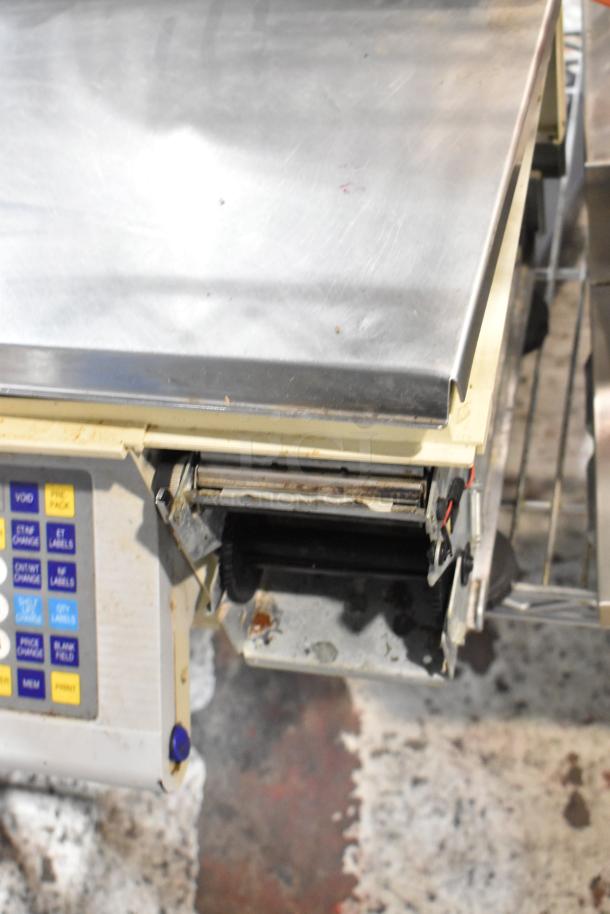 Stainless steel commercial scale with electronic keypad, visible wear and rust, ideal for parts or repair.