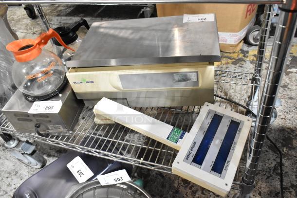Mettler Toledo scale on metal cart with coffee pot and labels. Slight wear visible.