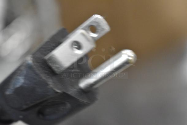 Close-up of a two-prong electrical plug with a black casing, showing slight wear. Suitable for general appliances.