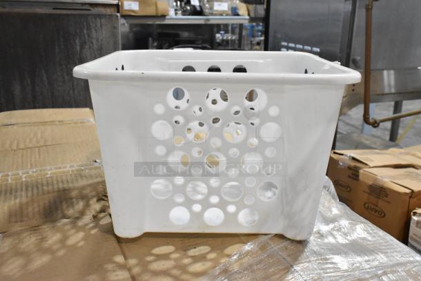 White plastic laundry basket with circular hole design, minor scuff marks, and sturdy build, placed on cardboard.