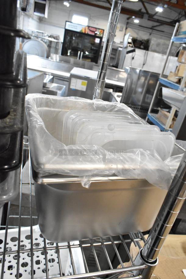 Stainless steel food storage bins on a metal rack, wrapped in plastic, showing durable commercial kitchen equipment.