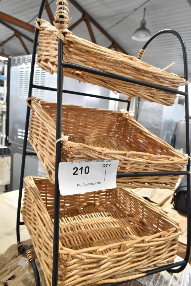 Three-tier wicker basket display rack with black metal frame, in good condition. Auction tag reads "210, PCIAuctions.com."