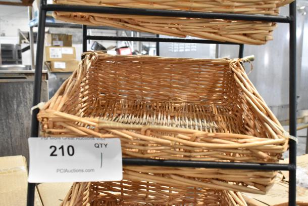 Wicker storage baskets on metal rack. Baskets in good condition. Auction tag reads "210 QTY 1," PCI Auctions website.