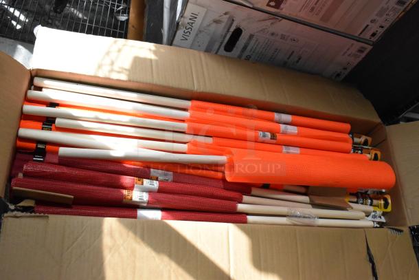 Box of orange and red mesh-covered flagging wands with wooden handles. Items are new with visible inventory labels.